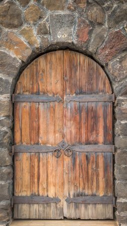 An old wooden door on a stone wall скачать фон 1080 x 1920