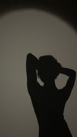 Силуэт девушки со спины в темноте